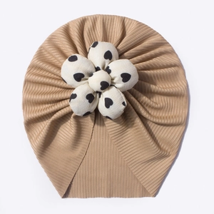 Detail view of khaki baby hat featuring a large 3D heart-printed flower on ribbed fabric