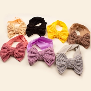 Detail view of seven colorful ribbed waffle fabric baby headbands with large bows