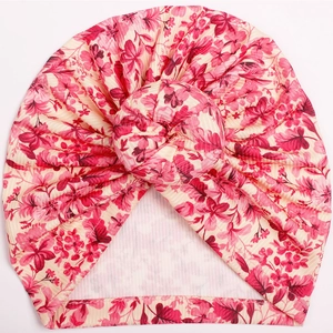 Close-up of floral print baby turban hat with decorative center knot and ribbed fabric