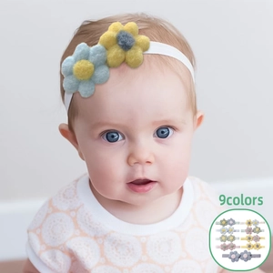 Détail montrant 9 couleurs de bandeaux fleurs pour bébé avec tissu élastique sur bébé