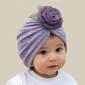 Dettaglio del turbante per neonati lavanda traforato con decoro di rosa viola