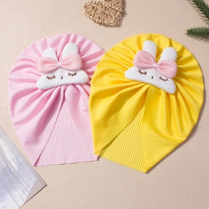 Close-up of ribbed knit baby turban hats with cute bunny patches and pink bows