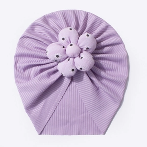 Close-up of baby purple turban hat featuring a large 3D flower and soft ribbed texture