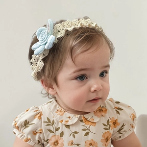 Close-up of baby girl wearing lace headband with light blue fabric flowers and rabbit ears