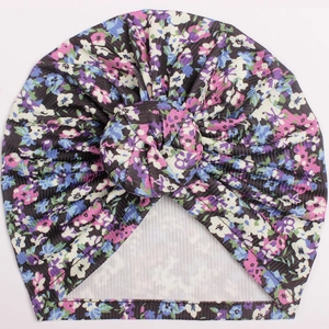 Detail of baby donut hat with floral print and ribbed knit stretch fabric texture