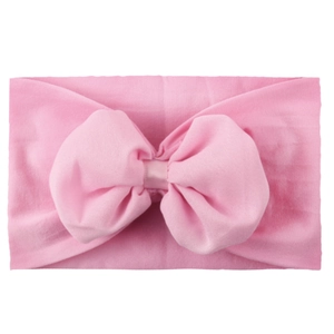 Gros plan d'un bandeau en nylon rose avec un nœud en mousseline pour bébés filles