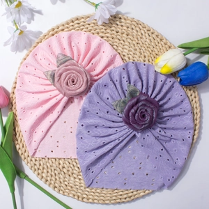 Dettaglio di cappelli turbante per neonati traforati con grandi rose in tessuto 3D e fiori
