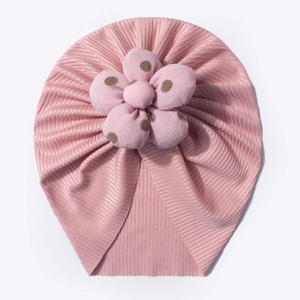 Detailed close-up of a pink ribbed baby hat featuring a 3D dotted knit flower on top