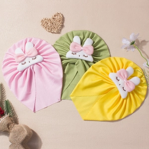 Set of three ribbed baby hats with cute rabbit ears and bows in pink, green, and yellow