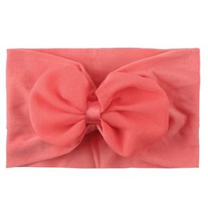 Gros plan d'un bandeau pour bébé rose corail avec un nœud en mousseline sur fond blanc