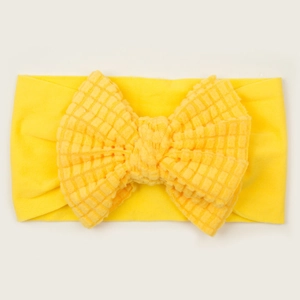 Macro view of bright yellow waffle knit bow headband for infants showing soft fabric texture