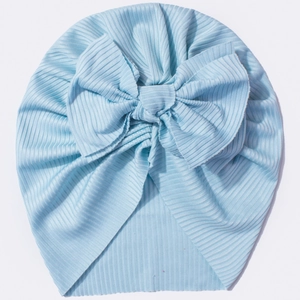 Detail of light blue ribbed knit baby turban with a large decorative bow on top