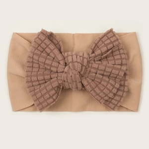 Close-up of caramel waffle knit texture and bow detail on soft baby headband