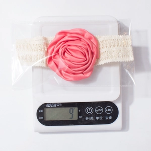 Détail du bandeau bébé rose en satin et dentelle blanche affichant un poids de 9g