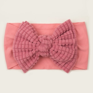 Detail of soft pink waffle texture oversized bow on stretchy newborn baby headband