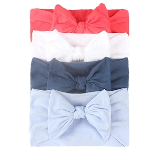 Detail view of 4-piece soft nylon baby headbands in coral, white, navy, and light blue