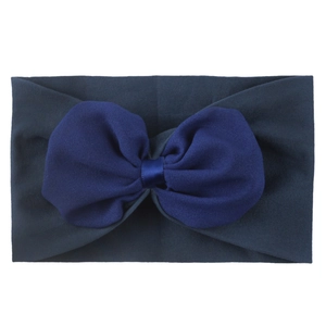 Détail d'un bandeau en nylon haute élasticité avec un nœud en mousseline bleue et doux