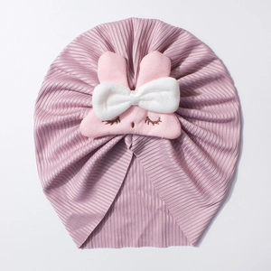Close-up of pink ribbed baby beanie featuring a plush bunny face and bow tie