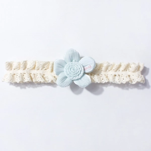 Detail of baby lace headband with light blue fabric flower and delicate hollow patterns