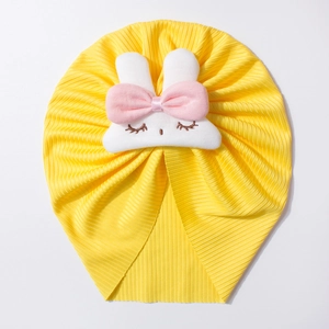 Detailed view of yellow ribbed baby hat featuring a 3D plush white bunny with pink bow