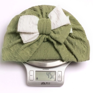 Detailed view of lightweight infant turban hat weighing 45.2g on a scale