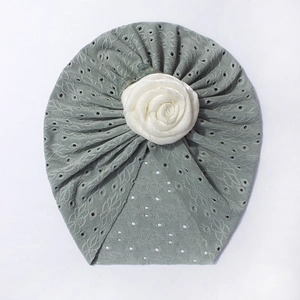 Dettaglio cappello turbante bebè traforato con rosa di raso bianco e tessuto a rete