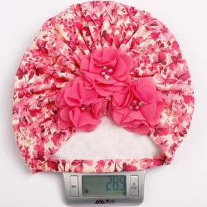 Pink floral baby turban cap weight showing 28.9g on a digital scale for detailed product spec