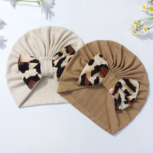 Detail of baby turbans with leopard bow and ribbed knit texture in neutral tones