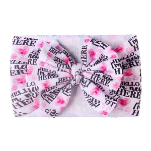 Dettaglio della fascia per neonati con cuori rosa e fiocco 'HELLO, I'M new HERE'