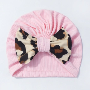Pink ribbed newborn turban hat featuring a large stylish leopard print bow accessory