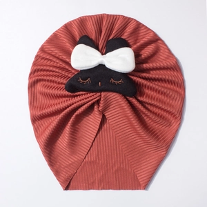 Detail of baby ribbed turban hat in rust red with cute black cat patch and white bow