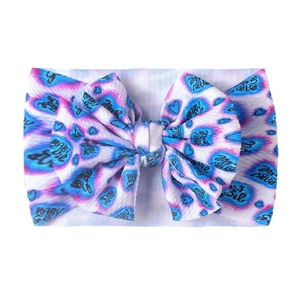 Dettaglio della fascia per neonata con fiocco tie-dye colorato e tessuto morbido