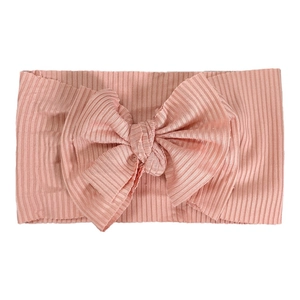 Vue détaillée de la texture tricotée côtelée rose clair du bandeau souple pour bébé