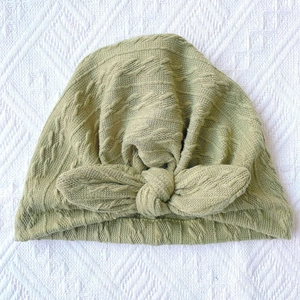 Close-up of olive green ribbed texture and soft knit knot on the infant turban hat