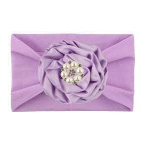 Close-up of light purple nylon baby headband with satin flower and rhinestone center