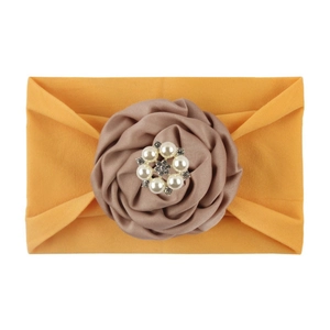 Detail of baby nylon headband featuring a large dusty pink fabric rose and faux pearl center