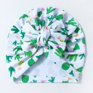 Detail of baby knot hat with green cactus print and large bow in soft waffle fabric