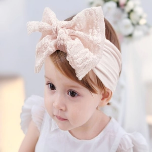 Close-up of soft pink lace bow baby headband on an infant with a comfortable elastic nylon band