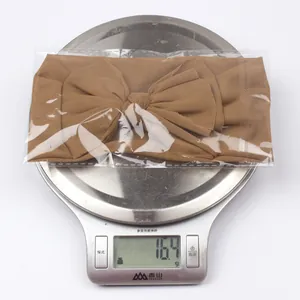 Detailed view of lightweight brown tulle bow headband weighing 16.4g on a digital scale