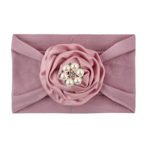 Detailed view of dusty rose baby nylon headband featuring a large satin flower and pearls