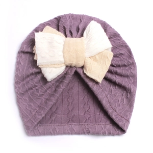 Macro detail of soft lavender baby turban hat featuring a layered white knit bow accent