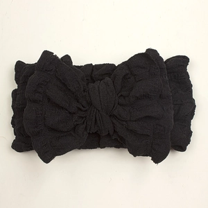 Detail of a large black bow headband with elastic wrinkled fabric for babies and toddlers