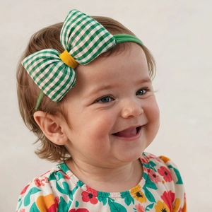 Detail of green gingham bow headband with yellow knot for infants on elastic band