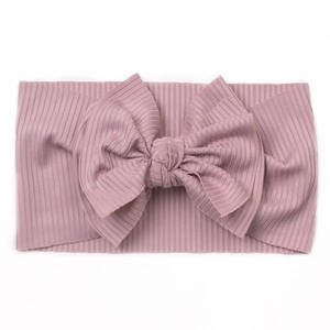 Détail d'un bandeau pour bébé en maille côtelée douce avec un grand nœud décoratif