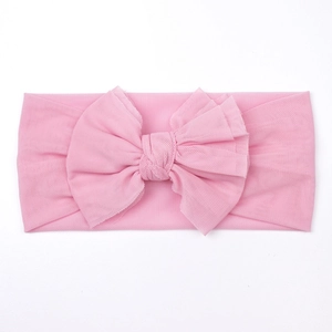 Detail of pink mesh baby headband featuring a large multi-layered bow and soft texture