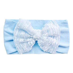 Detail of baby headband featuring soft blue elastic fabric and large white lace bow