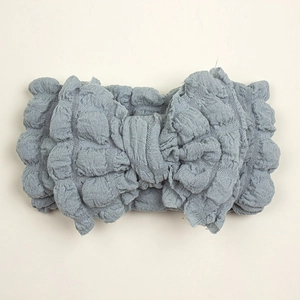 Detailed view of dust blue baby headband with bubble texture fabric and bow knot
