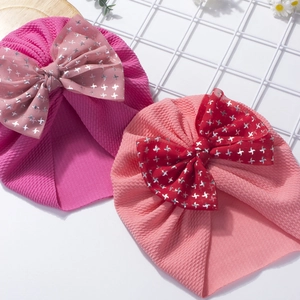 Detailed view of baby waffle knit bow headband with silver star print in pink and rose red