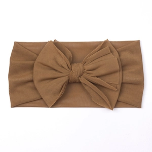 Detailed macro view of the soft mesh texture and large bow on this brown baby headband