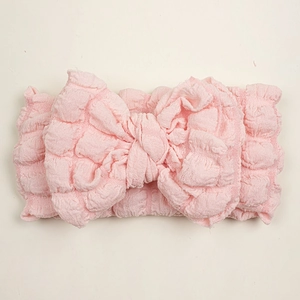 Detail of soft pink seersucker baby headband with a large decorative bow